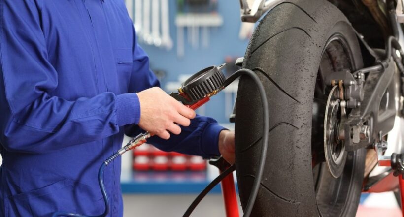 Imagen de una persona inflando un neumático a propósito de cuál debe ser la presión ideal en las llantas de las motos