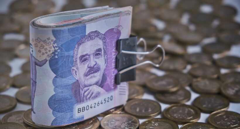 Billetes de 50 mil pesos y monedas de mil, ilustran nota sobre irregularidades en pagos del Ingreso Solidario y otros subsidios en Colombia.