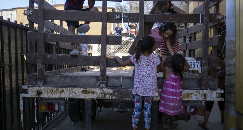 Imagen de niños colgados de un camión ilustra artículo Más de 59 millones de desplazados internos en el mundo en 2021