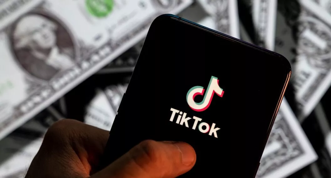 CHINA - 2021/04/23: In this photo illustration, a TikTok logo seen displayed on a smartphone with USD (United States dollar) currency in the background. (Photo Illustration by Budrul Chukrut/SOPA Images/LightRocket via Getty Images)
