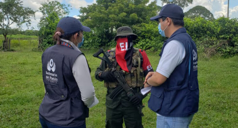 Un guerrillero del Eln y dos delegados de la Defensoría del Pueblo, en la entrega de secuestrados de este 12 de agosto en Arauca.