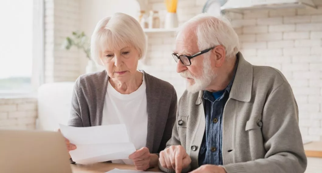 Adultos consultando documentos ilustran nota sobre dónde revisar fondos de pensión, cesantías y EPS a las que se está afiliado