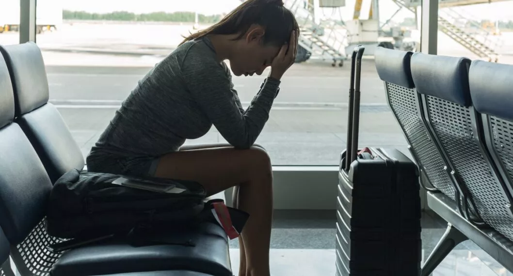Passenger waiting at the airport terminal, stressed about missing her flight