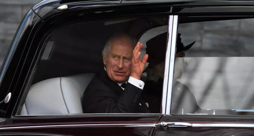 Rey Carlos III saludando desde su carro ilustra nota de cuánto vale su vehículo que funciona con vino 