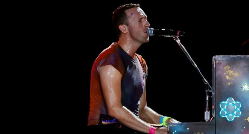 Foto del cantante Chris Martin, de Coldplay, tocando el piano en concierto.
