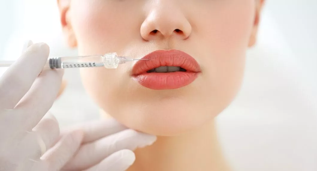 Closeup of crop anonymous female patient getting filler injection in lips in cosmetology clinic