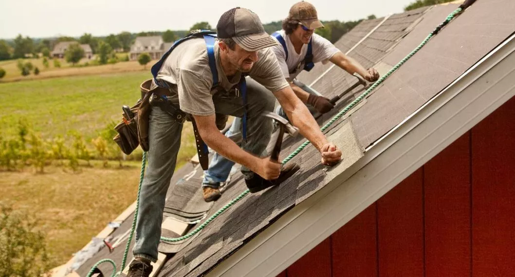 Foto de dos obreros trabajando en el techo de una casa a propósito de la reforma laboral en México