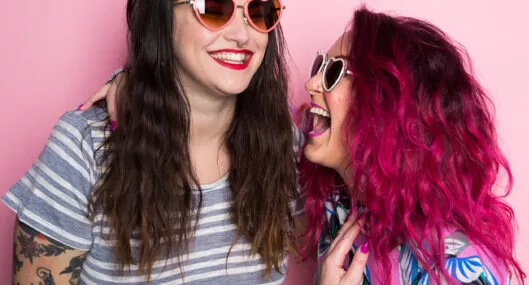 Mujeres riendo con el cabello de colores. Nota sobre cómo usar laca de color para el cabello.