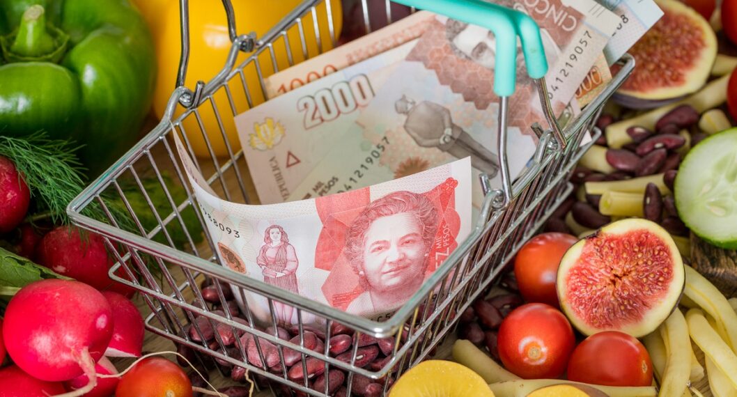 Dinero colombiano y frutas. Nota sobre qué es la inflación y cómo afecta los bolsillos de los colombianos.