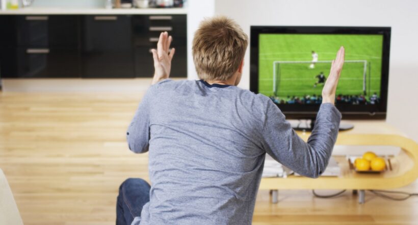 Hombre viendo fútbol. Nota sobre la programación de fútbol para el jueves 6 de octubre de 2022.