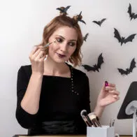 Joven maquillándose para Halloween. Nota sobre los errores más comunes al maquillarse para Halloween.