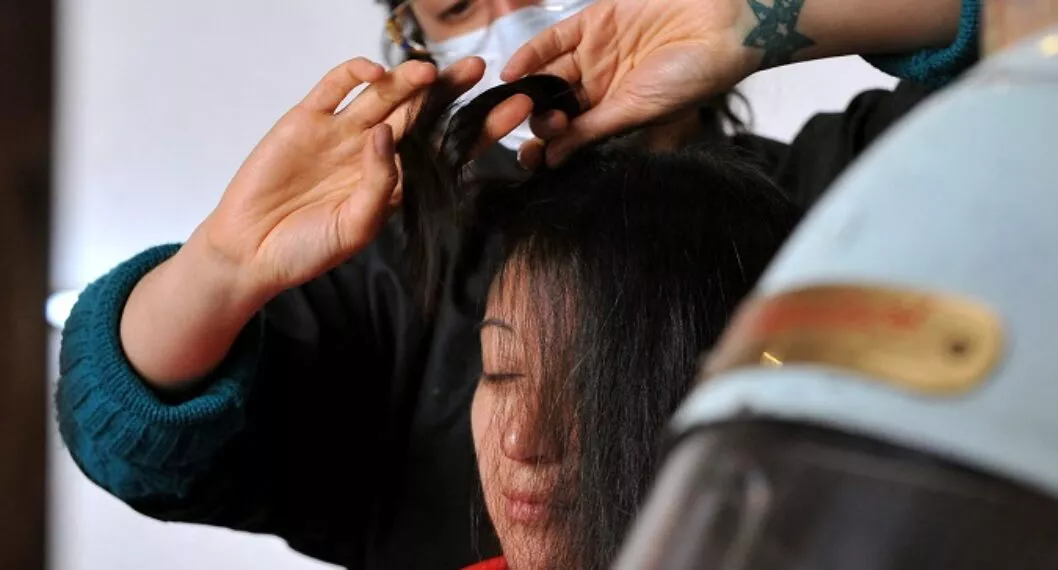 Imagen de mujer peinando a otra ilustra artículo Productos para alisar el cabello aumentan riesgo de cáncer de útero