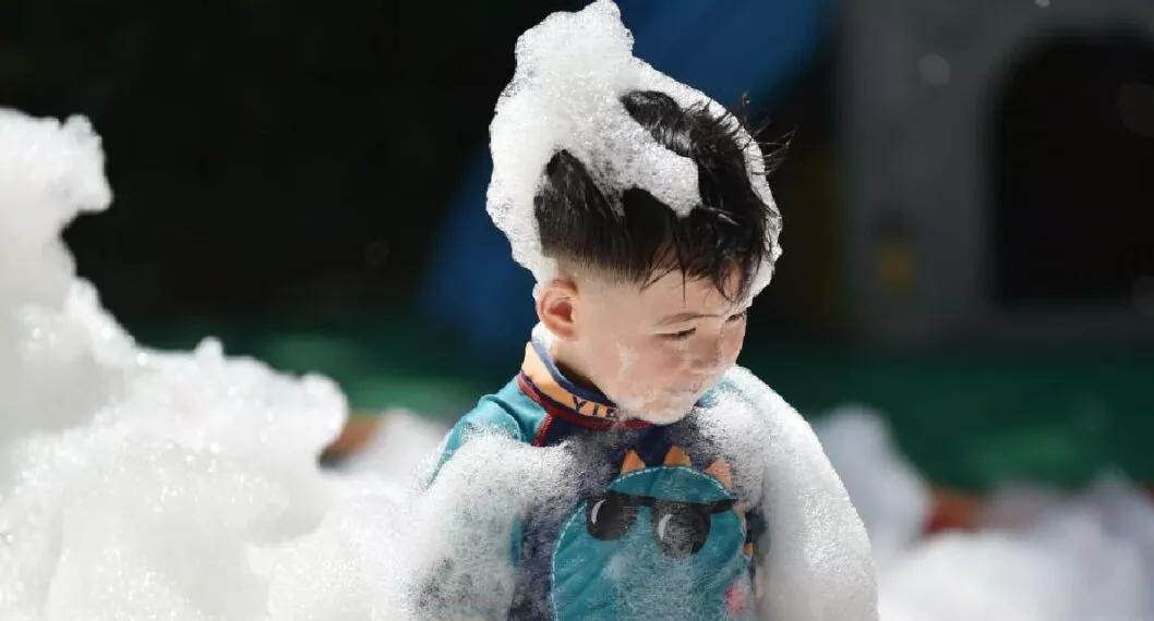 Foto de un niño entre pompas de jabón a propósito de un niño que se hizo viral en Twitter por desperdiciar jabón