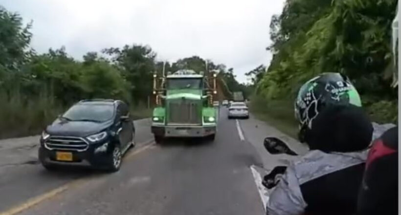 Tractocamión por poco arrolla a pareja de motociclistas por intentar sobrepasar dos carros que estaban parqueados en la vía. Se salvaron de milagro. 