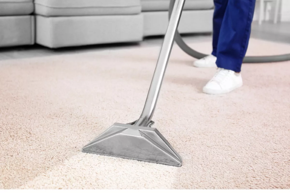 Persona aseando una alfombra a propósito de la forma correcta de limpiarlas.