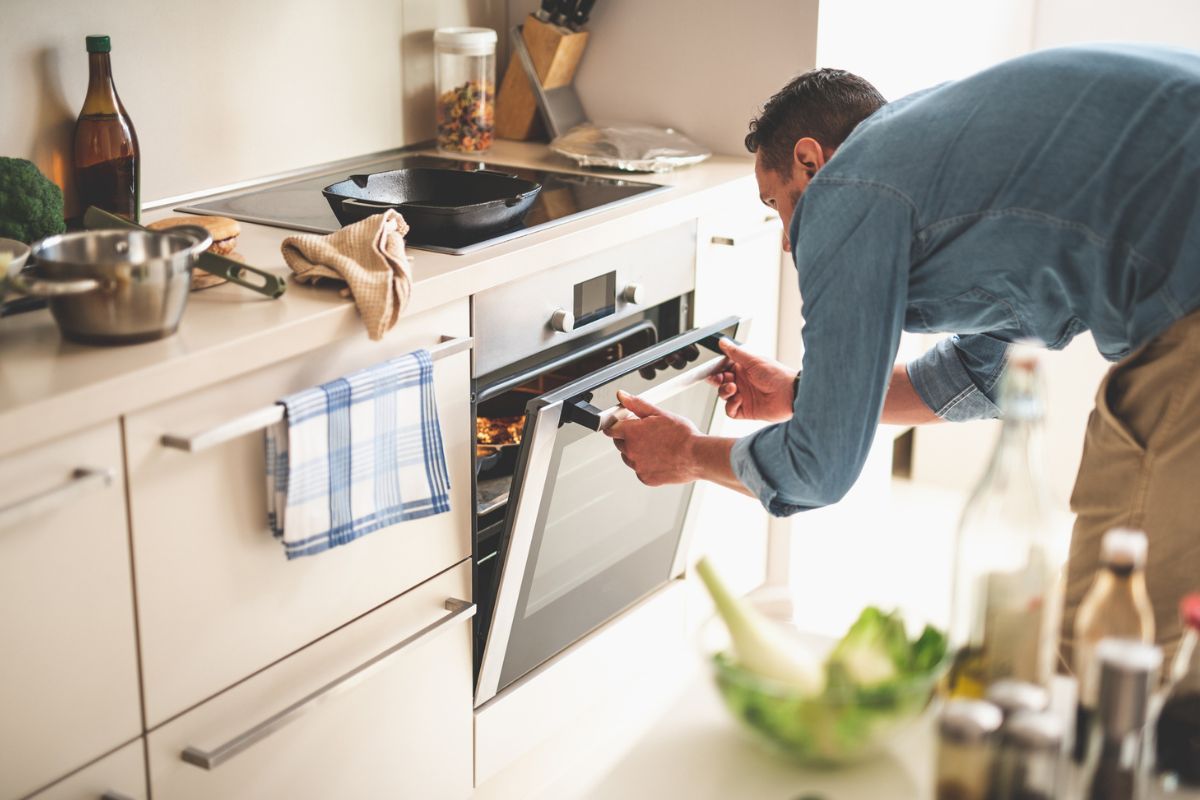 Persona abriendo un horno a propósito del truco para limpiarlo correctamente.