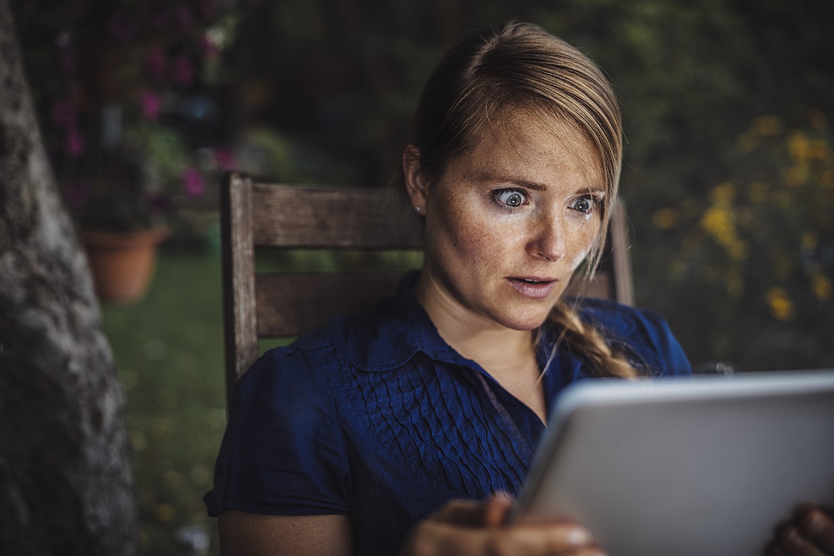 Foto ilustrativa de mujer con la tablet asombrada para nota de una joven que se dio cuenta que le iban a reemplazar en su empleo.