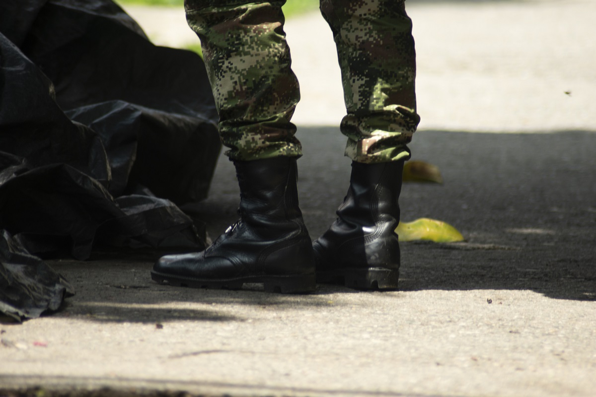 Pies de un soldado caminando en la calle. En relación con enfrentamiento en Cali.