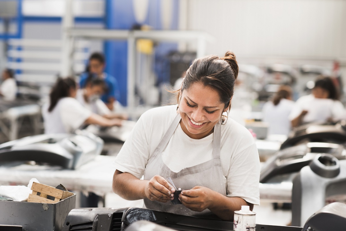 Empleada sonriendo. En relación con la horas laboradas en Colombia.