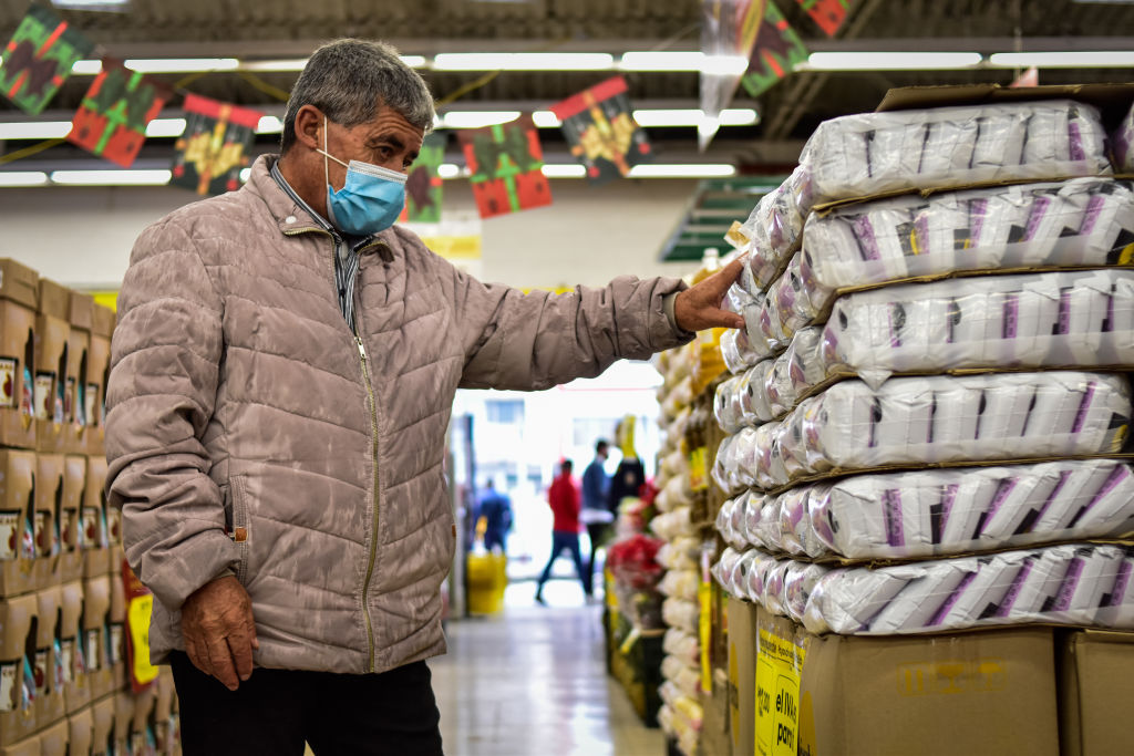 Hombre mirando precios en un supermercado, a propósito de las 10 marcas más consumidas en Colombia