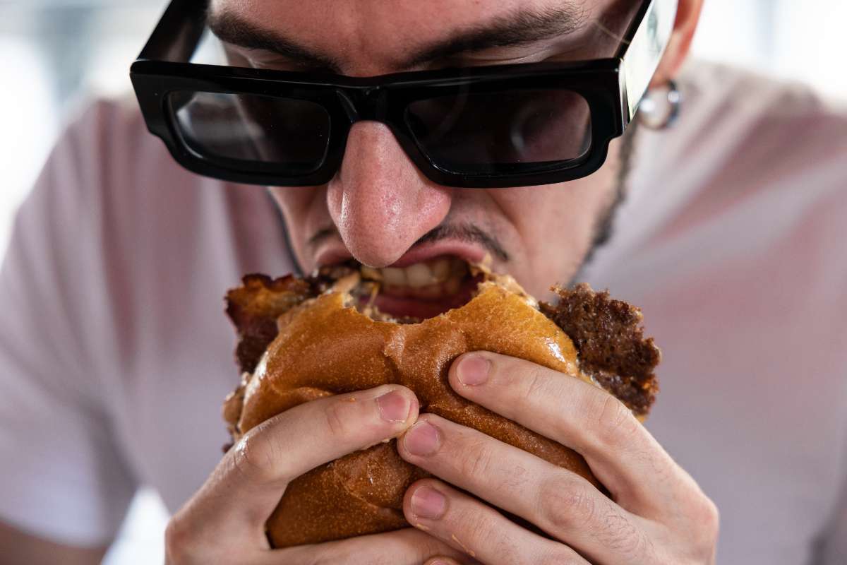 Foto de hombre comiendo hamburguesa, en nota de Home Burgers y por qué asusta a El Corral, McDonalds y Burger King en Colombia.