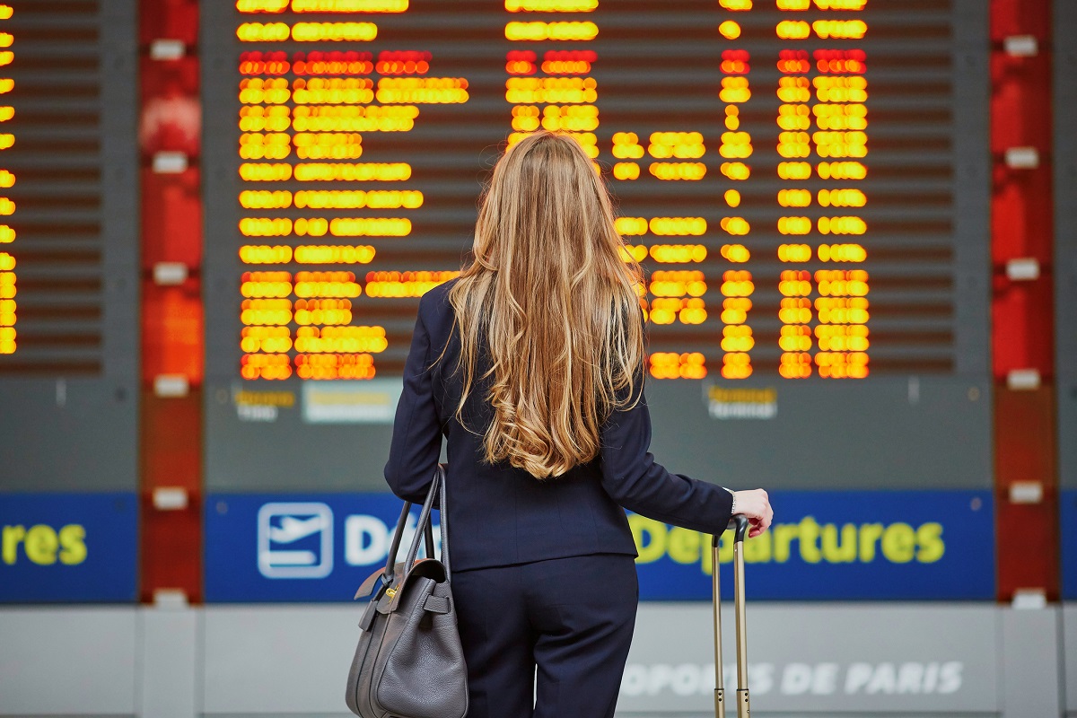 Mujer mirando pantalla de aeropuerto, en nota sobre países a donde puede ir sin pasaporte y con cédula