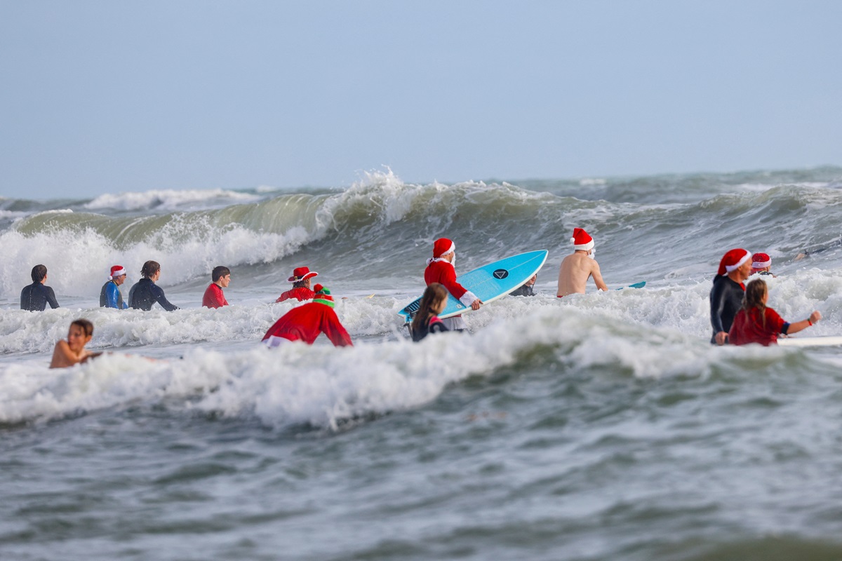 Papás Noel surfistas se toman playa de Florida por diversión y una buena causa