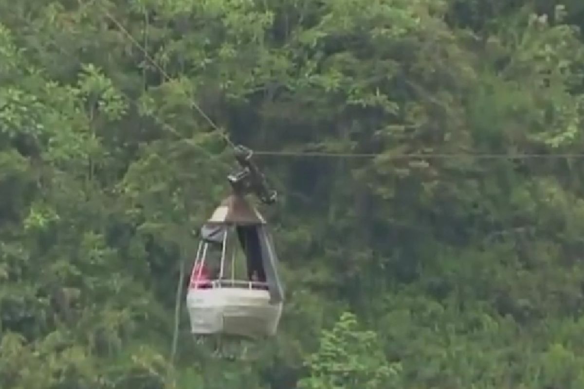 Tratan de rescatar a cinco personas atrapadas en teleférico más de 250 metros de altura.