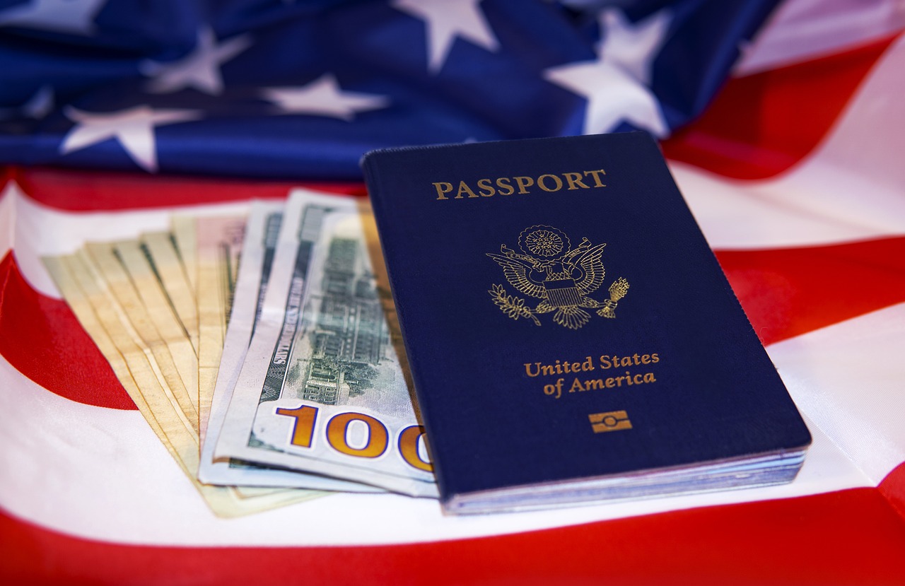 Foto de pasaporte, dólares y bandera de Estados Unidos, a propósito de si es bueno o no pedir la visa en familia: detalles