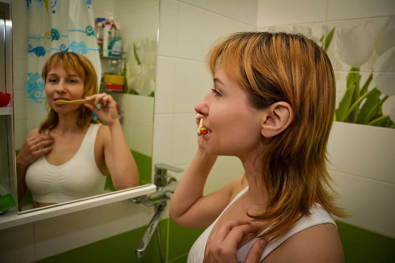 Foto de mujer cepillado dentadura, en nota sobre cuántas veces hay que lavarse los dientes al día: recomendaciones y mito que es dañino