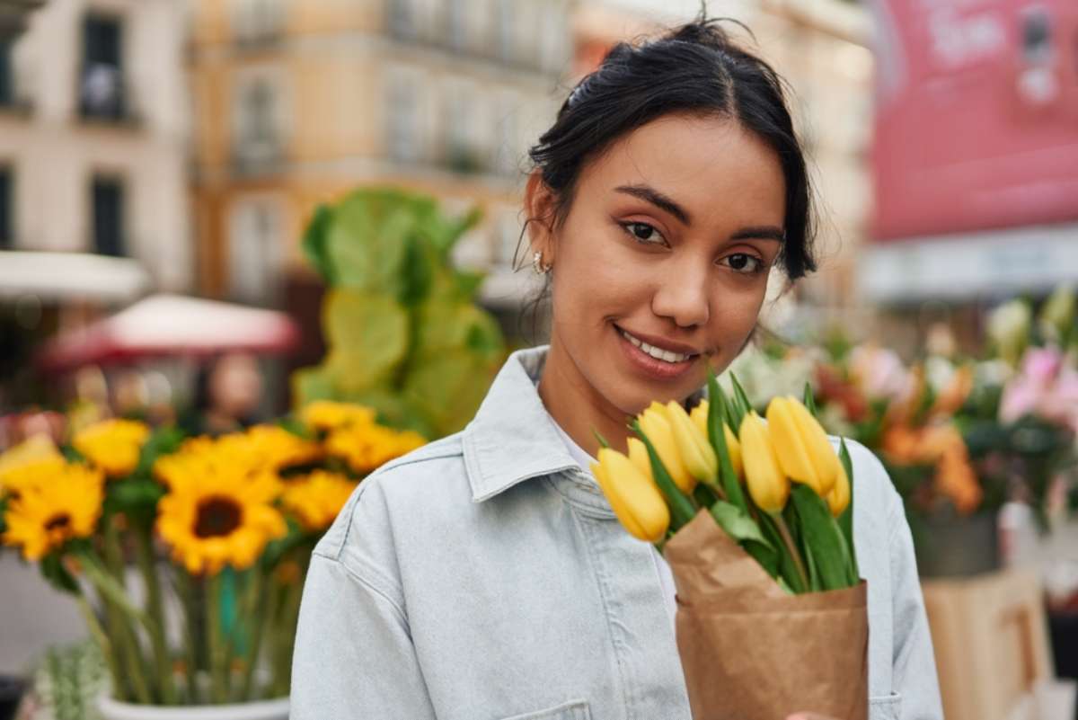 Foto de mujer con flores amarillas, en nota de por qué se regalan el 21 de marzo y cuál es su significado clave