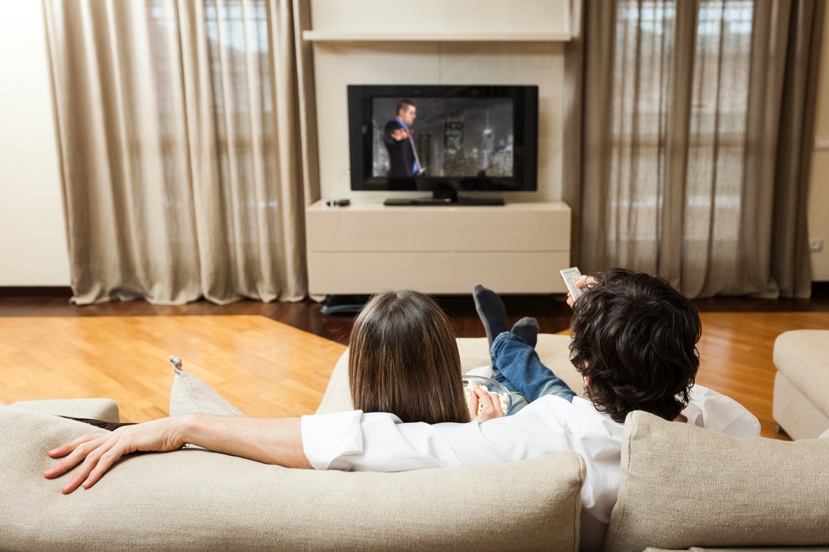 Personas viendo televisión en nota sobre cómo tener más canales en el televisor