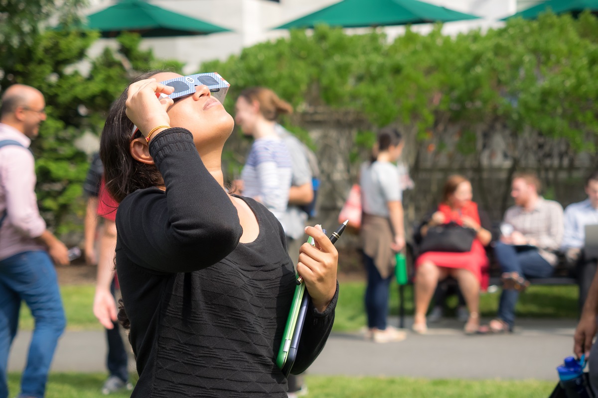 Mujer mirando eclipse solar, en nota sobre por qué no usar gafas de cine para verlo