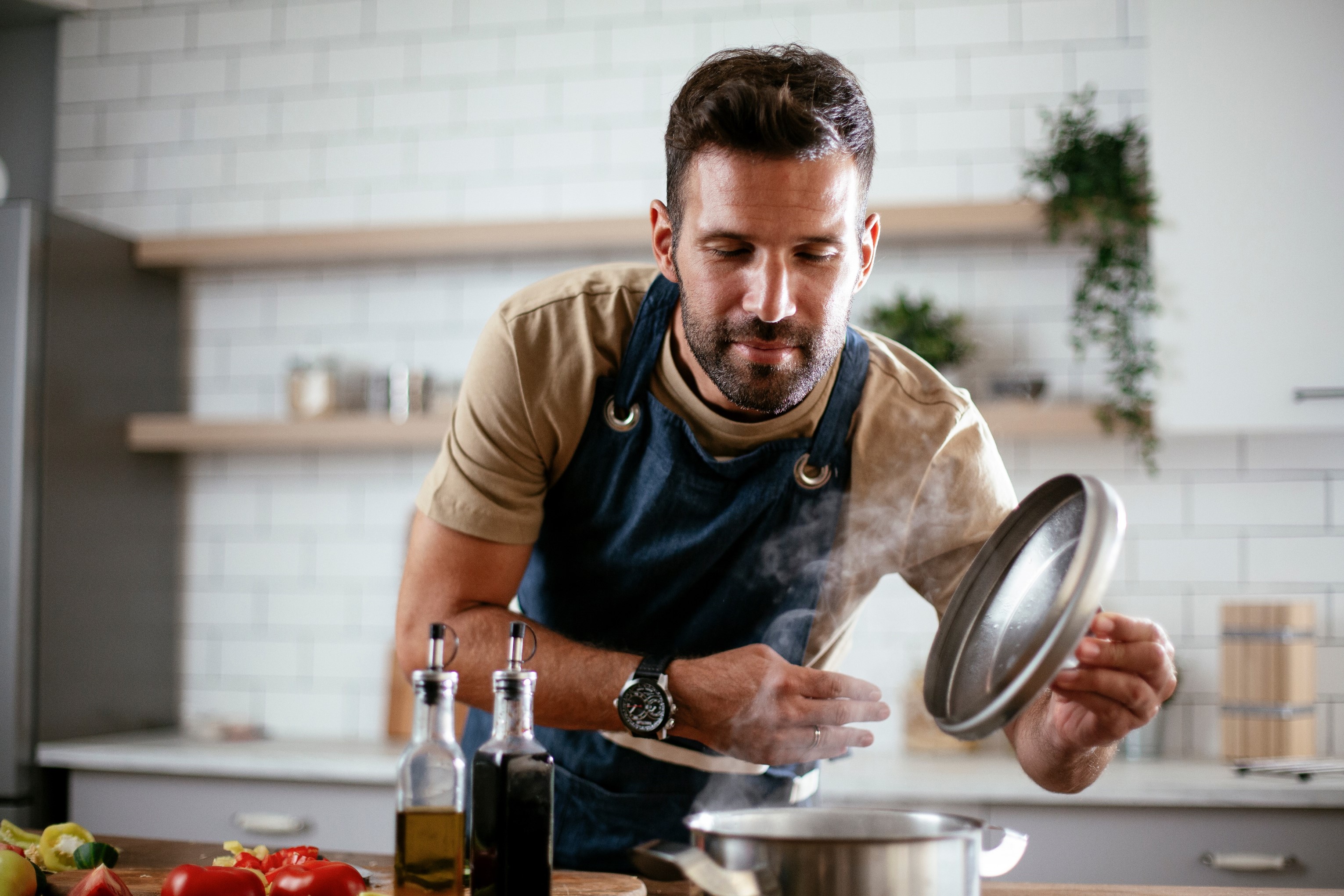 Foto de hombre cocinando, en nota sobre cómo sacar el olor a comida de la casa con trucos caseros si no se tiene extractor