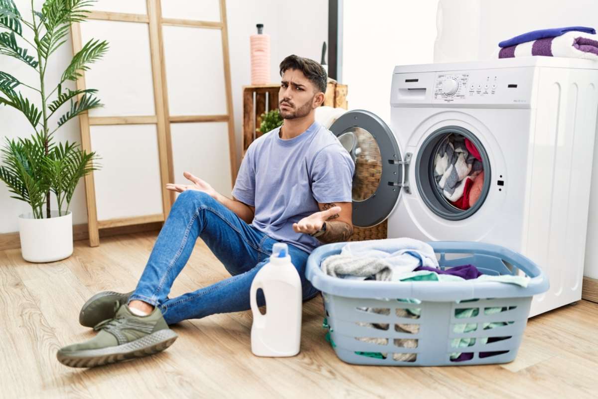 Foto de hombre con lavadora, en nota de qué hacer para que no se encoja la ropa con trucos para que no pase y quede nueva