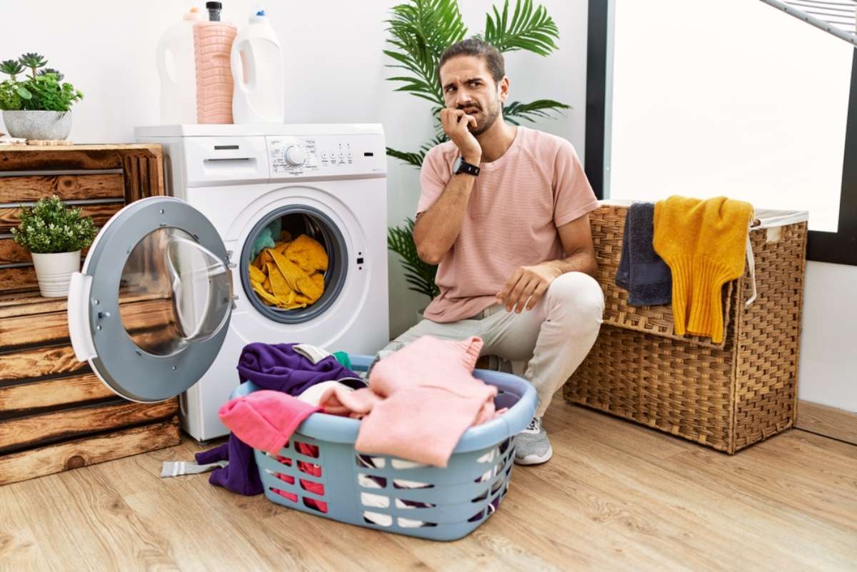 Foto de hombre lavando, en nota sobre por qué las medias desaparecen en la lavadora.