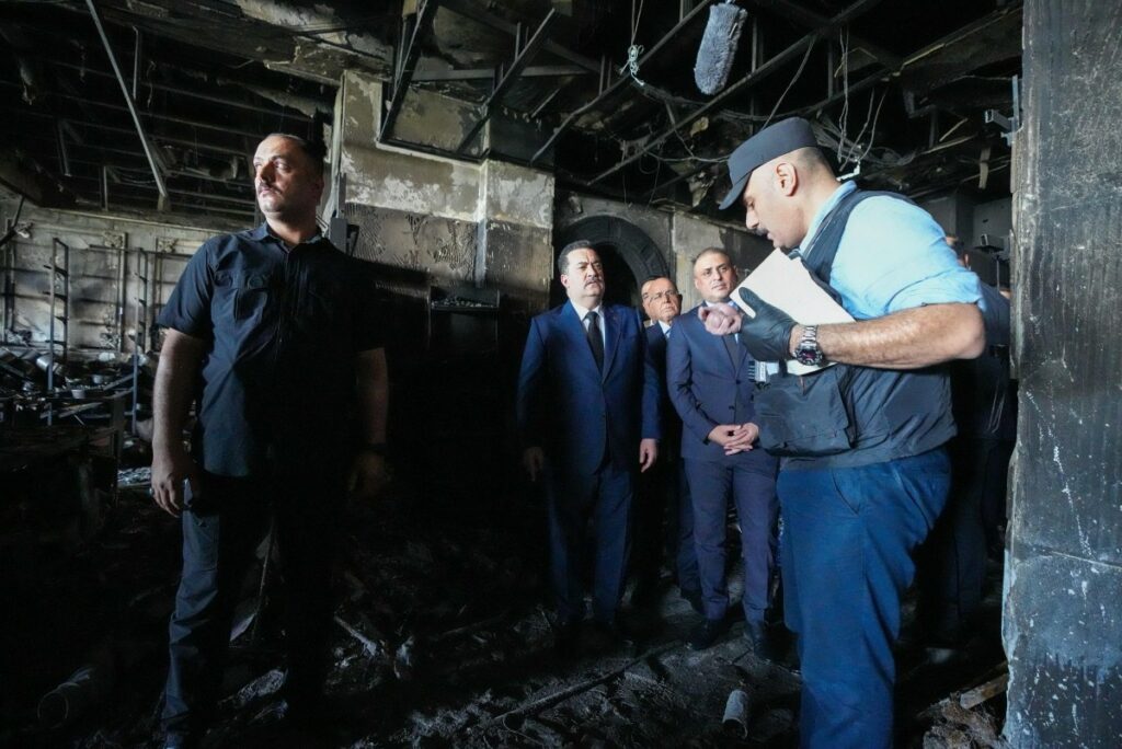 El primer ministro de Irak dentro del centro comercial en Kut, luego de que quedase destruido por un incendio / AFP