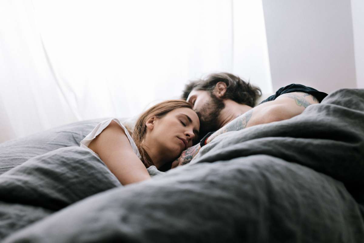 Foto de pareja durmiendo, en nota de qué es dormir a la Noruega, para acabar peleas de pareja en cama, y cómo hacerlo