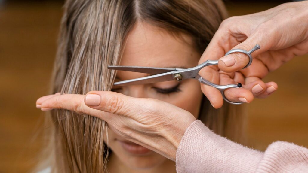 Mujer cortándose el cabello / Freepik
