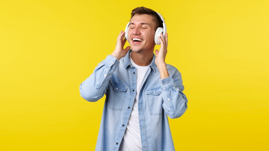 Hombre escuchando música con audífonos / Freepik 
