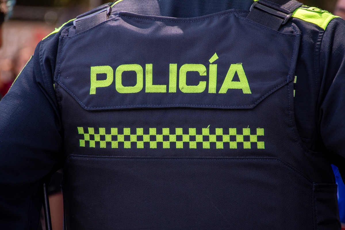 Close-up "POLICE" marking written on the back of a bulletproof vest worn by a Colombia police officer. Concepts of security, crime and police cases in Colombia