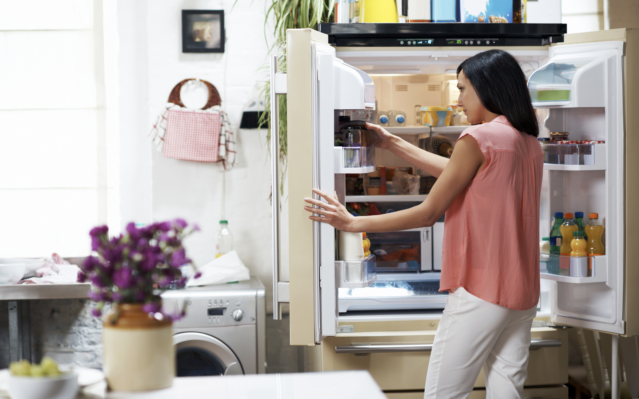 Woman looking in the fridge in her cozy loft apartment