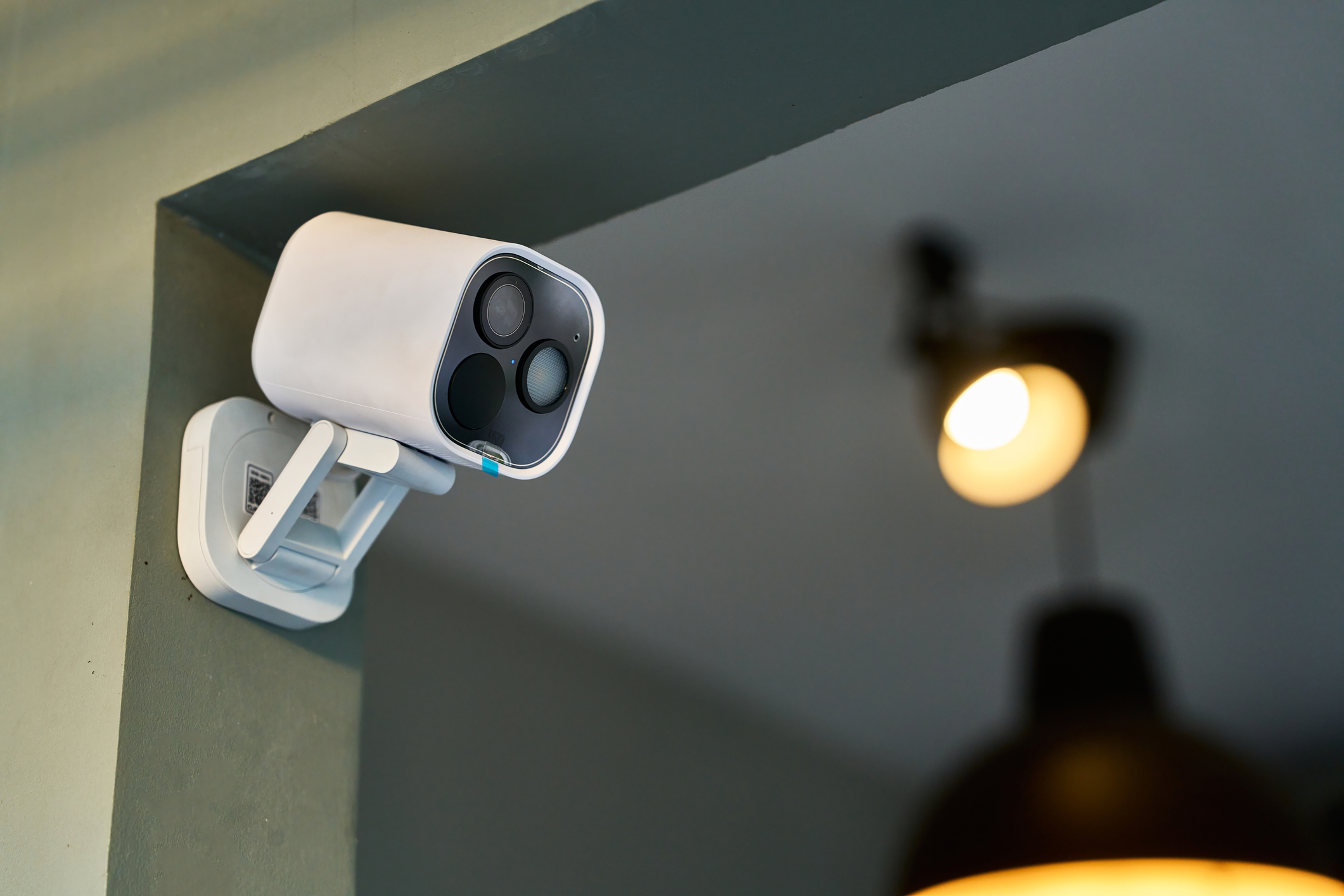 White security camera mounted on a wall, continuously monitoring the room and providing enhanced safety and surveillance through cutting-edge technology and smart design
