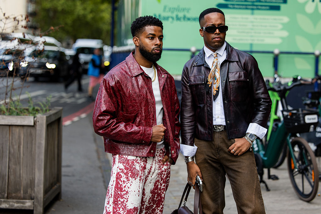 LONDON, ENGLAND - SEPTEMBER 17: A guest (L) wears a red distressed leather jacket, a white t-shirt, red and white splatter pattern trousers, and a gold chain outside Mark Fast on September 17, 2026 in London, England. (Photo by Christian Vierig/Getty Images)