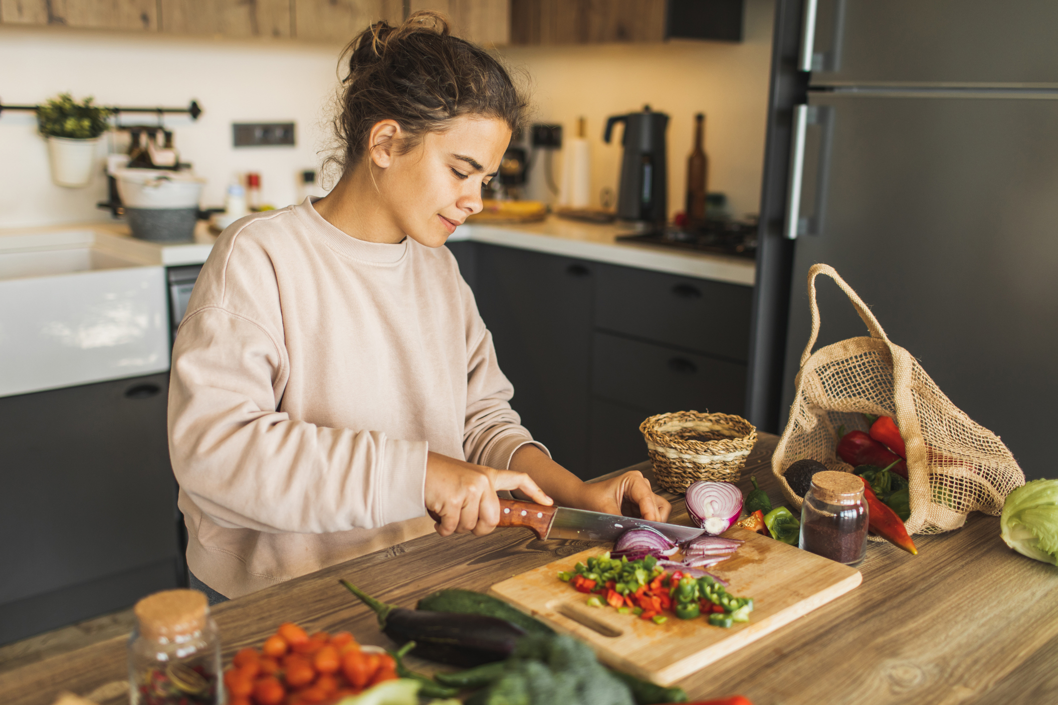 Fresh and healthy raw organic food. Farm vegetables. Vegetarian meal preparation. Young pretty woman cooking at home.
