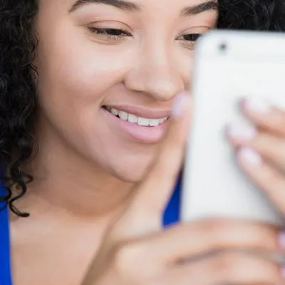 Foto de mujer mandando un mensaje, a propósito de còmo programar un iPhone para enviar mensajes de WhatsApp automáticamente