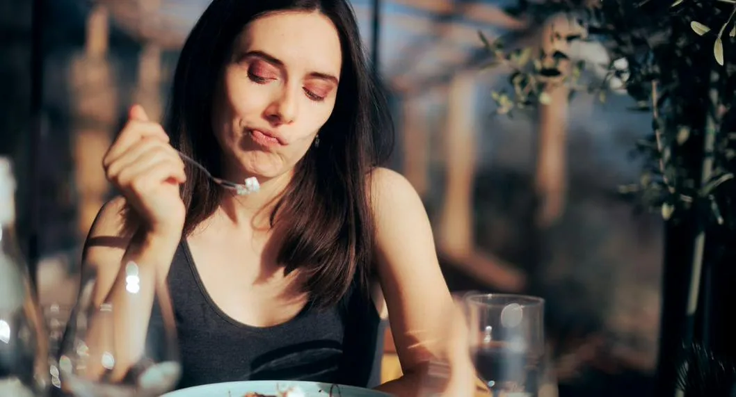 Mujer duda de comer un postre ilustra nota sobre los beneficios de dejar de consumir azúcar 
