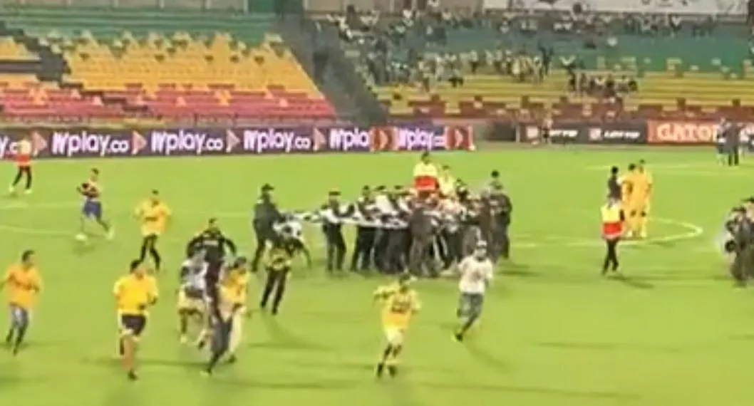 Hinchas del Bucaramanga se metieron a la cancha en el partido contra el Tolima. El juego estuvo detenido varios minutos mientras los retiraban. 