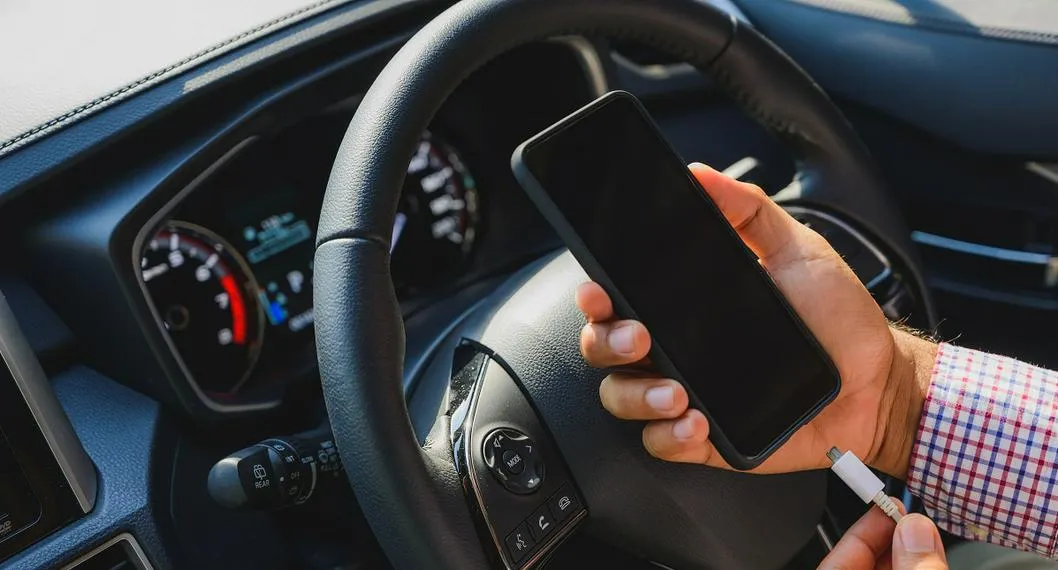 Conductor se dispone a cargar el celular en su vehículo. Le contamos los riesgo a los que se puede enfrentar por recurrir a esta práctica.