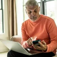 Foto de hombre con calculadora frente a computador, en nota de viviendas de interés social en Colombia cambiarían por decisión de constructoras